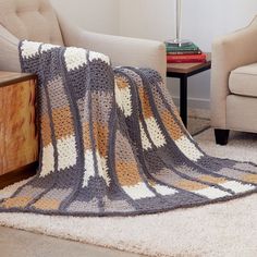 a living room with two chairs and a crocheted blanket