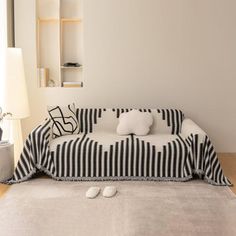 a living room with a couch covered in a black and white blanket