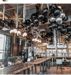 an image of a restaurant with balloons hanging from the ceiling and tables in front of it