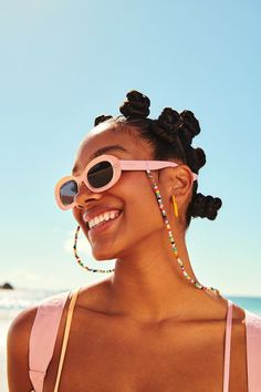 a woman wearing pink sunglasses on the beach