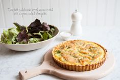 there is a quiche next to a bowl of salad