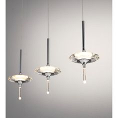 three lights that are hanging from the ceiling in different shapes and sizes, with one light on