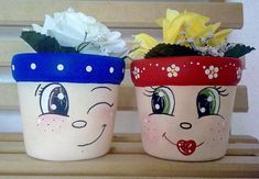 two flower pots with faces painted on them