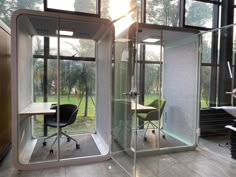 an office area with glass walls and chairs