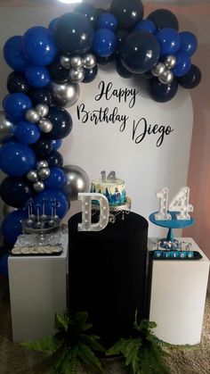 a birthday party with balloons, cake and decorations in blue and silver colors on display