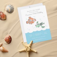 an ocean themed baby shower with starfish and seashells on the sand next to it