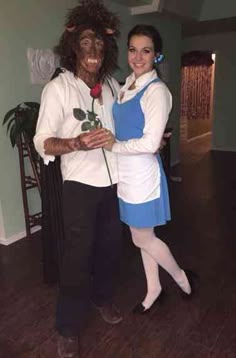 a man and woman dressed up as characters from beauty and the beast pose for a photo