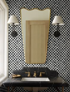 a bathroom with black and white checkered wallpaper, gold framed mirror and sink