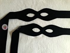 two black masks are sitting on a white surface with one being cut out and the other is closed