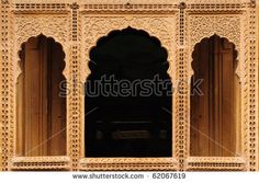 an intricately carved wall with arched windows