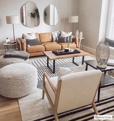 a living room filled with lots of furniture and mirrors on the wall above it's windows