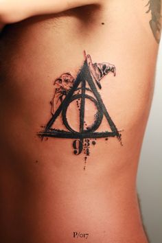 a harry potter tattoo on the side of a woman's stomach, with an image of deathly hall