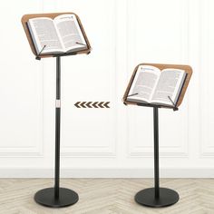 an open book is sitting on a stand next to another one with an arrow pointing towards it