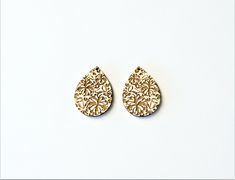 two pairs of gold colored earrings on a white background, one is shaped like a tear