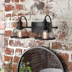 two lights on a brick wall above a mirror