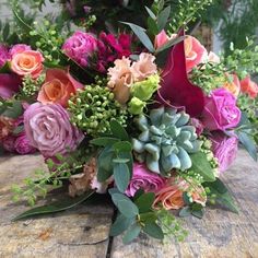 a bouquet of flowers sitting on top of a wooden table