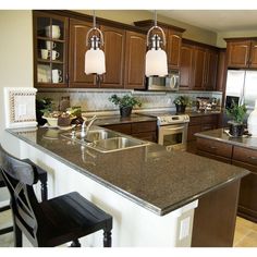 a large kitchen with wooden cabinets and granite counter tops, along with stainless steel appliances