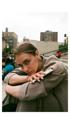 a woman leaning on her arm while looking at the camera