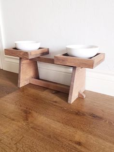 two bowls sit on top of a wooden stand