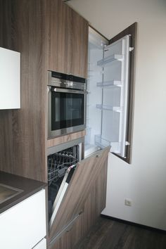 an open refrigerator door in a kitchen next to a stove top oven and microwave combination