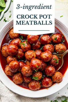 a white bowl filled with meatballs covered in sauce and garnished with parsley