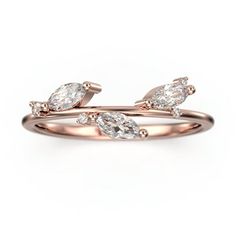 a rose gold ring with three pear shaped diamonds on the top and bottom, set against a white background