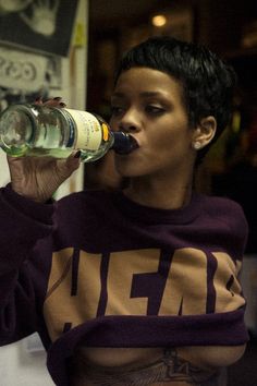 a woman with tattoos drinking from a bottle