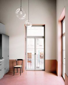 an empty room with pink floors and white walls