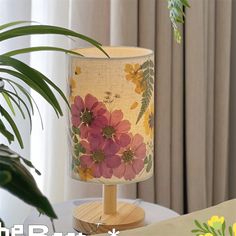 a lamp that is sitting on top of a table next to a potted plant