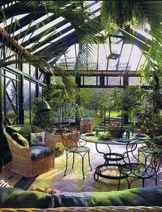 the inside of a greenhouse with tables, chairs and plants in it's center