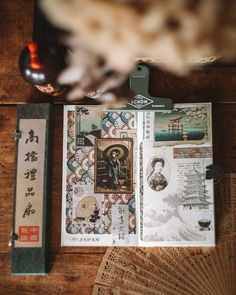 an open book sitting on top of a wooden table next to a fan and other items