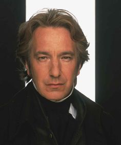 a close up of a person wearing a suit and tie with a white background behind him