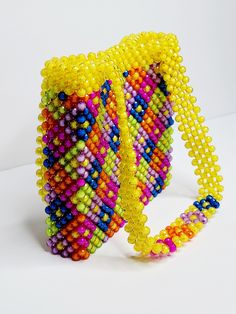 This beaded handbag is a true original! At approx. 9"X 8"X 2" It's the perfect size for your phone, keys and cards.  The 20" strap is great for over the shoulder and nestles high and securely.  Also a wonderful length to carry by handle down by the hip.  Made of acrylic beads, so its super easy to handwash when needed.  Made by Lora Rolling.  Ships to US (only) via USPS.  Arrives within 7 days! All sales are final. Questions? Text 214-872-0062 Everyday Rectangular Shoulder Bag With Colorful Beads, Multicolor Beaded Crossbody Shoulder Bag, Multicolor Rectangular Bag With Colorful Beads, Multicolor Rectangular Shoulder Bag With Colorful Beads, Travel Multicolor Beaded Shoulder Bag, Multicolor Beaded Handheld Shoulder Bag, Multicolor Beaded Rectangular Shoulder Bag, Yellow Beaded Rectangular Bag, Yellow Beaded Bag For Everyday Use