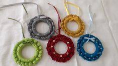 four crocheted wreaths with bows are on a white sheet and tied together