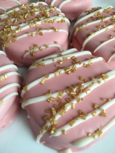 some pink and white cookies with gold sprinkles on top of each one