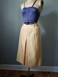 "Vintage 90s yellow pencil skirt with back clasp and zipper closure. Front has a pretty geomentric pleat. No obvious flaws or imperfections. Unsure of maker as there are no tags.  Built in slip. Flat measurements are as follows: Waist: 12.5\" Hip: 18\" Waist to Hem:  26\"" Elegant Yellow Pleated Bottoms, Vintage Fitted Knee-length Pleated Skirt, Fitted Pleated Pencil Skirt For Summer, Fitted Yellow Pencil Skirt For Spring, Vintage Fitted Pleated Skirt For Work, Retro Fitted Pleated Skirt For Workwear, Vintage Yellow Fitted Skirt, Fitted Retro Pleated Skirt For Work, Fitted Vintage Pleated Skirt For Work