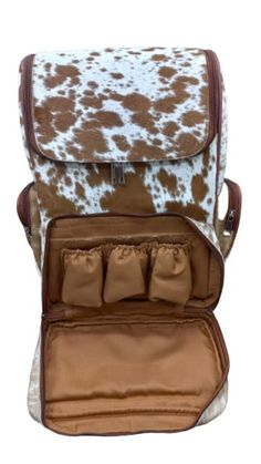 a brown and white cow print bag with three small pouches in the bottom compartment