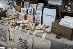 there are many bags on the table with cards and other items for sale at this market