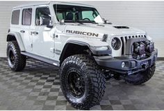 a white jeep is parked on a checkered floor