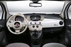 the interior of a small car with steering wheel and dash lights, dashboard panel and center console