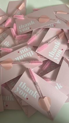 pink thank you notes with heart cutouts on them are scattered in a pile together