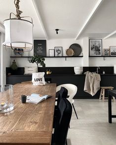 a dining room table with chairs and pictures on the wall