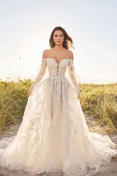 a woman in a wedding dress standing on the beach