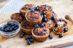 some blueberry muffins are sitting on a cutting board