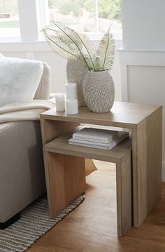 a living room with a couch, coffee table and two vases on the end tables