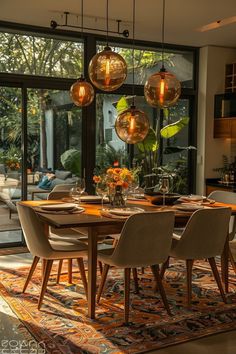 a dining room table with chairs and lights hanging from it's centerpieces