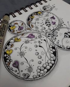 a coloring book with an image of some flowers and butterflies on it, next to a marker