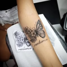 a woman's arm with butterflies and the words resilince written on it