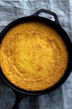 a close up of a skillet with food in it on a tableclothed surface