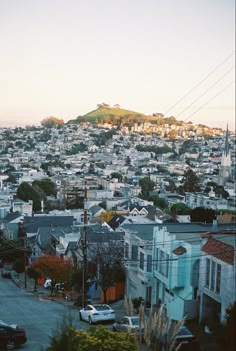 a city with lots of houses and hills in the background